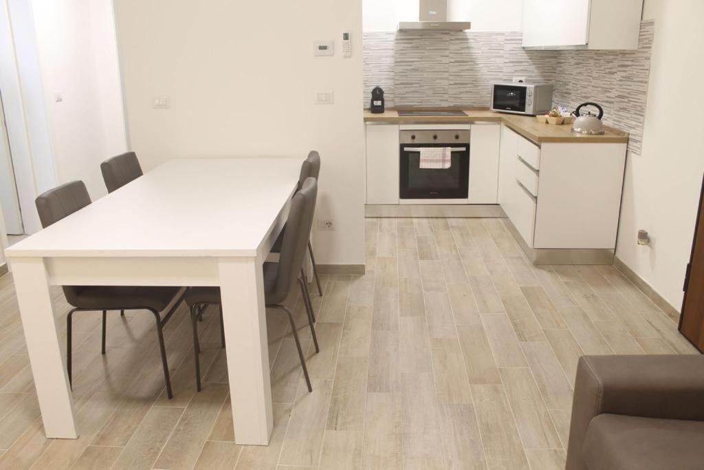 a kitchen with a white table and chairs at Appartamento San Vitale in Bologna