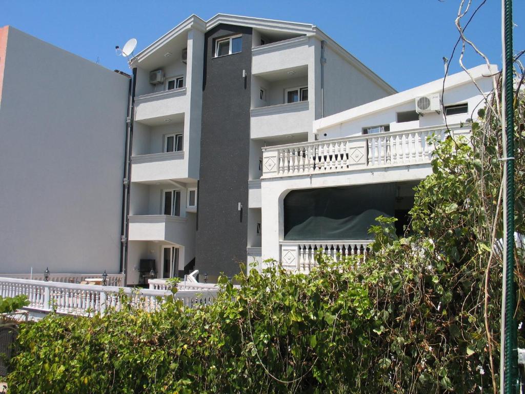 a white apartment building with a white balcony at Guest House Dena in Dobra Voda