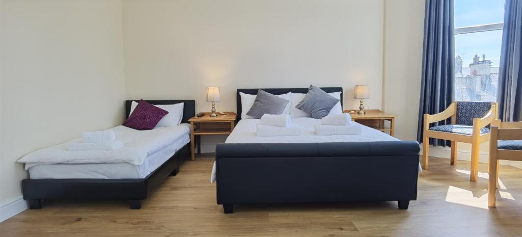 - une chambre avec 2 lits, une table et des chaises dans l'établissement Comfy 2 bedroom Apt in central location, Newly Refurbished, à Plymouth
