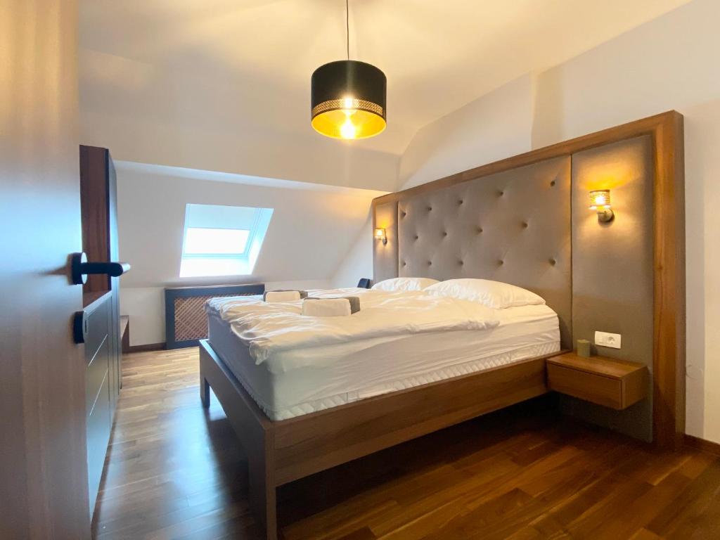 1 dormitorio con 1 cama con cabecero y luz en Olimian Retreat Rosa 421, en Podčetrtek