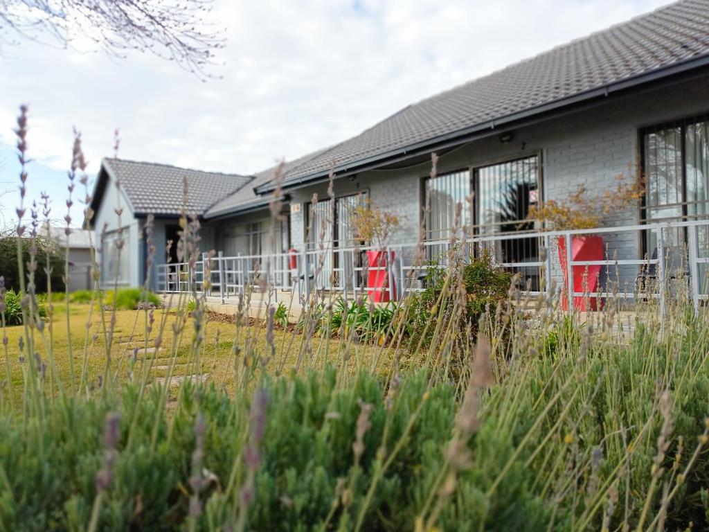 a house with red chairs in front of it at 21 On Coetzee Guest House in Bloemfontein