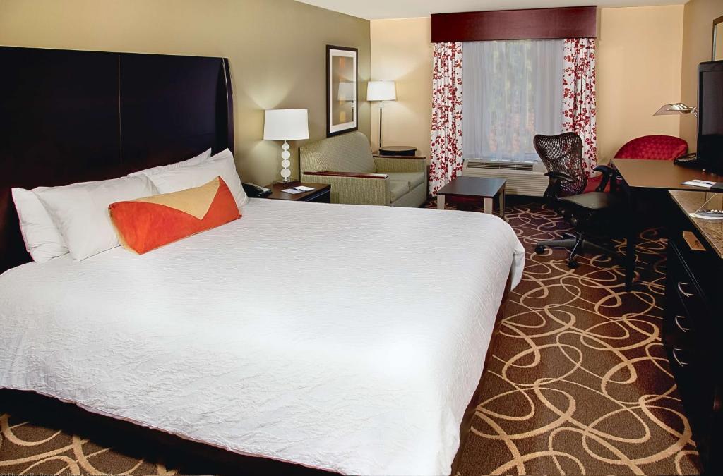 a hotel room with a large bed and a living room at Hilton Garden Inn Atlanta/Peachtree City in Peachtree City