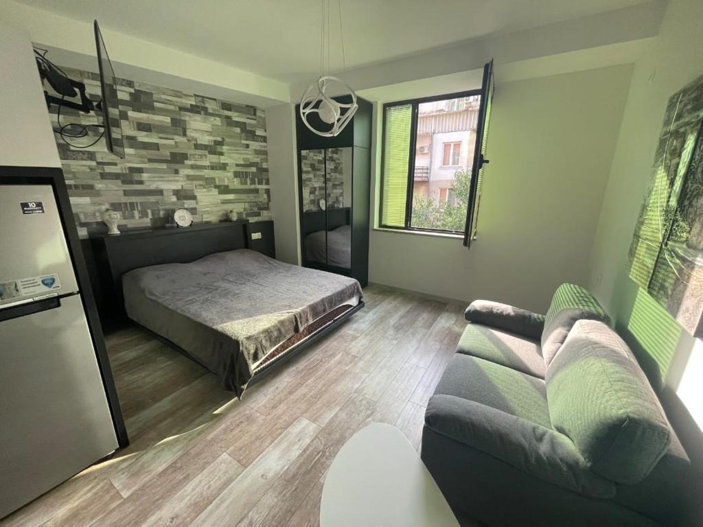 a bedroom with a bed and a couch at Royal Plaza Apartment -10A in Tbilisi City