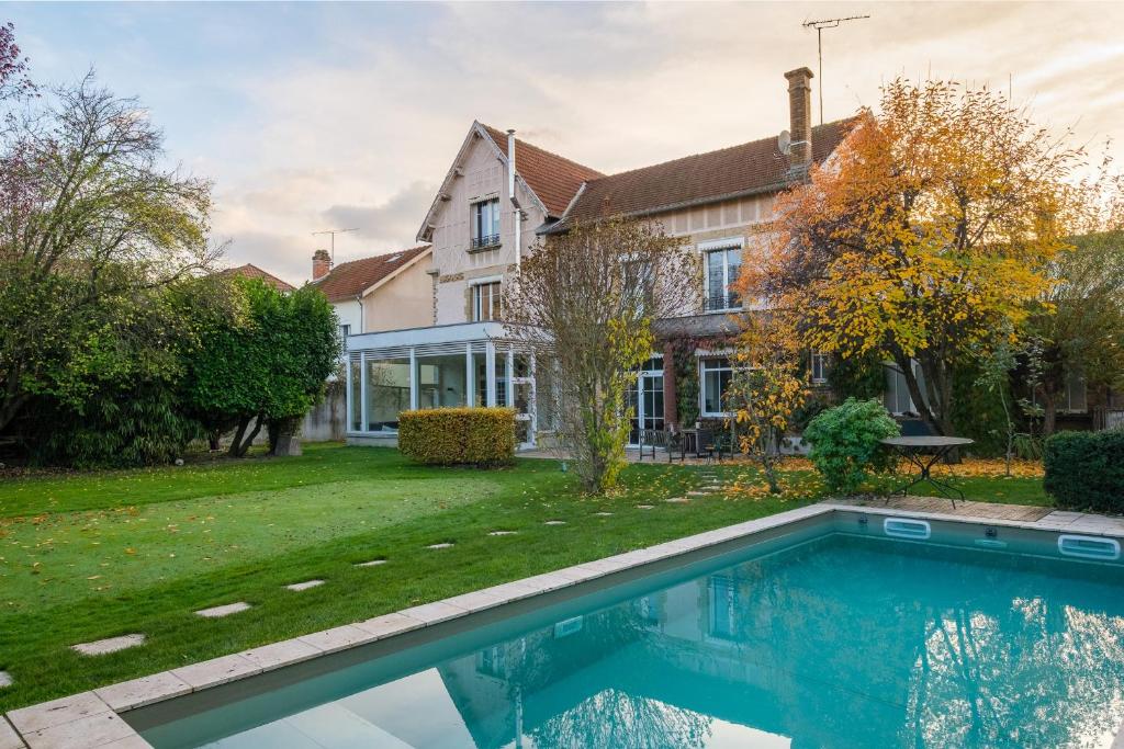 a house with a swimming pool in front of a yard at Le Grenier à Sel in Châlons-en-Champagne
