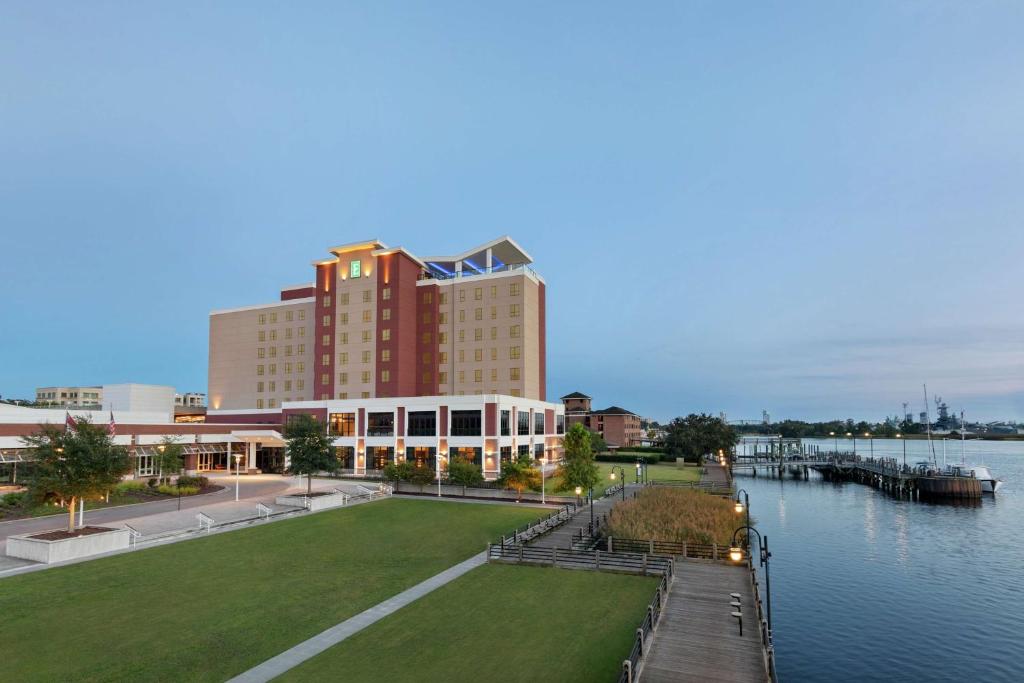 威尔明顿Embassy Suites By Hilton Wilmington Riverfront的靠近水域的大型建筑