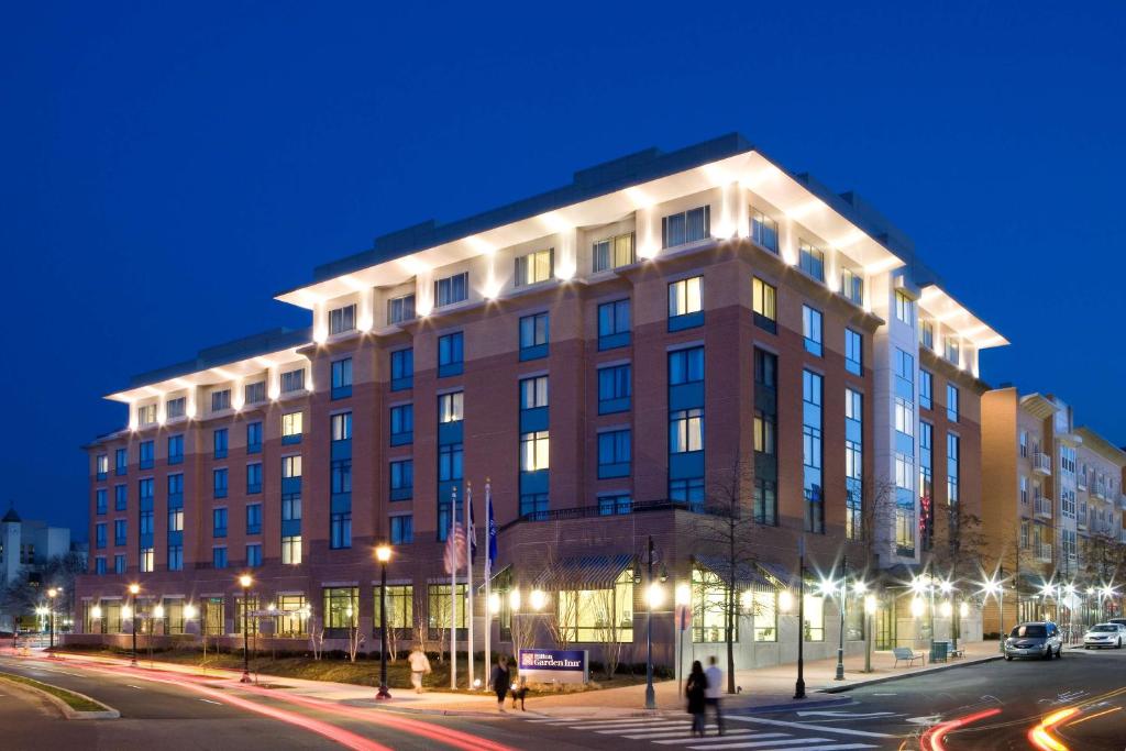 a large building on a city street at night at Hilton Garden Inn Shirlington in Arlington