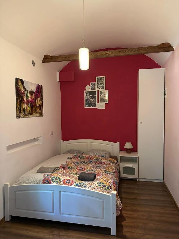 1 dormitorio con cama y pared roja en City Centre Apartment Wielopole en Cracovia