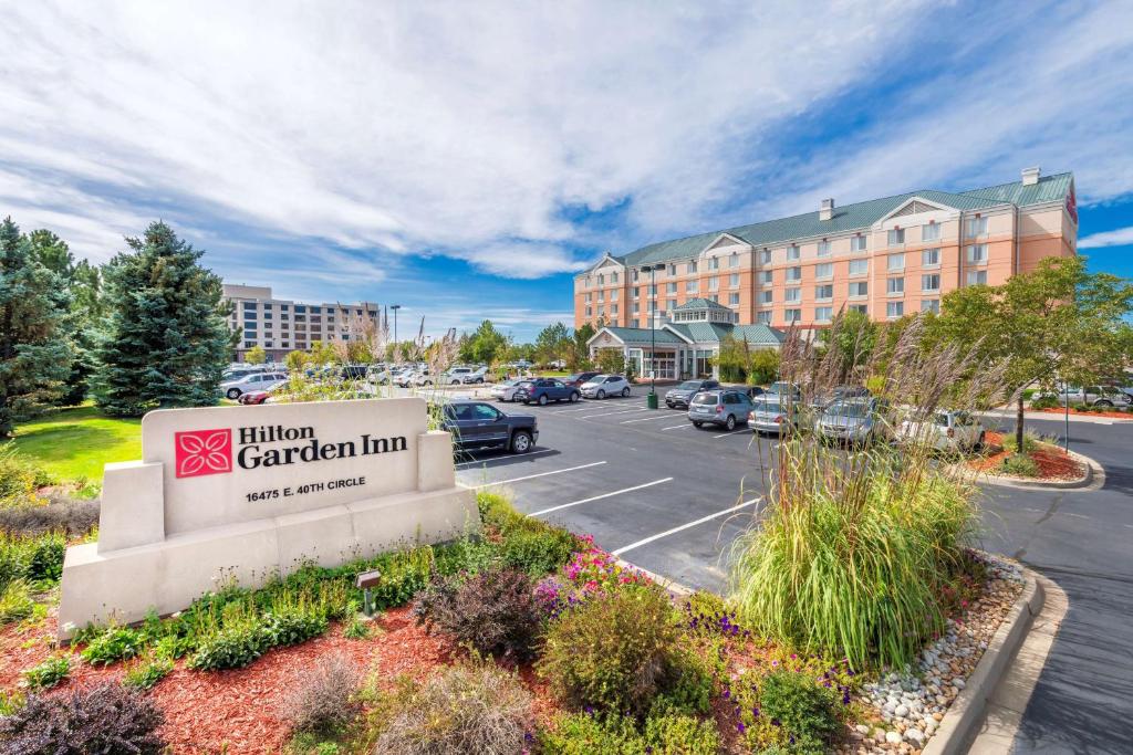 um sinal para a pousada Aiken Garden com estacionamento em Hilton Garden Inn Denver Airport em Aurora