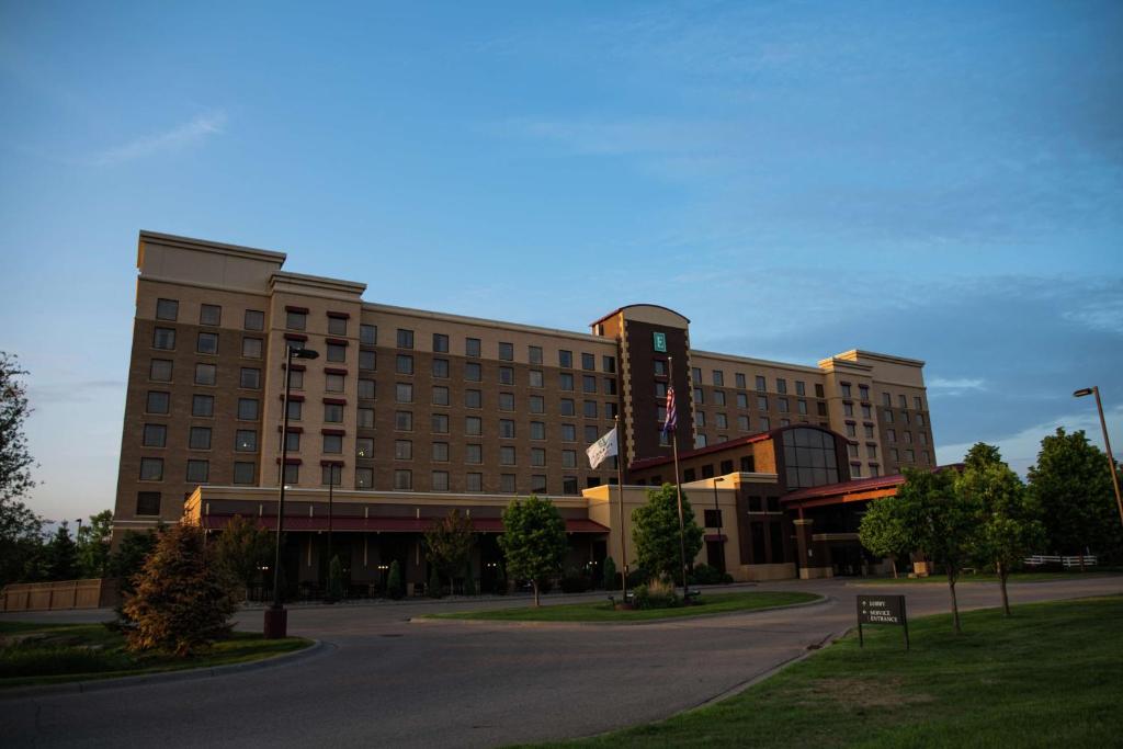 a large building with a street in front of it at Embassy Suites by Hilton Minneapolis North in Brooklyn Center