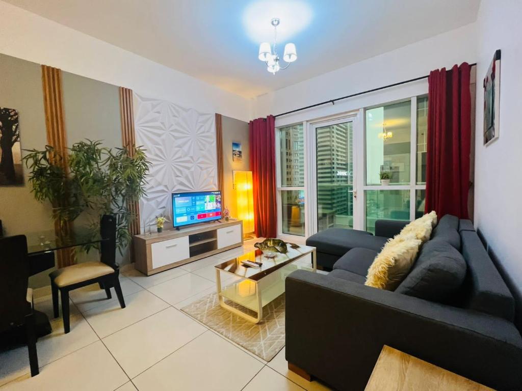 a living room with a couch and a tv at SKY NEST HOLIDAY HOMES 1 bedroom Apartment dubai marina 2903 in Dubai