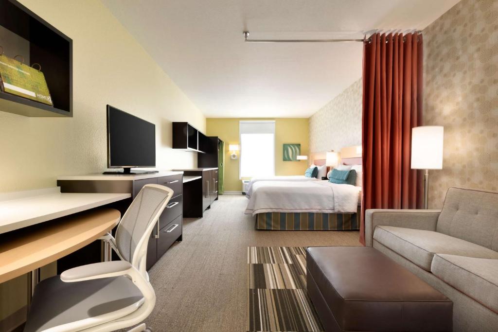 ein Hotelzimmer mit einem Schlafzimmer mit einem Bett und einem Schreibtisch in der Unterkunft Home2 Suites by Hilton Cleveland Independence in Independence