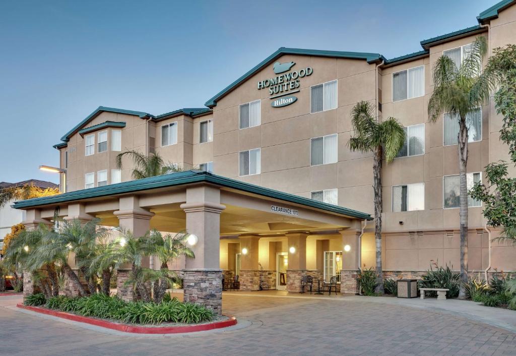 a hotel building with palm trees in front of it at Homewood Suites by Hilton San Diego-Del Mar in San Diego