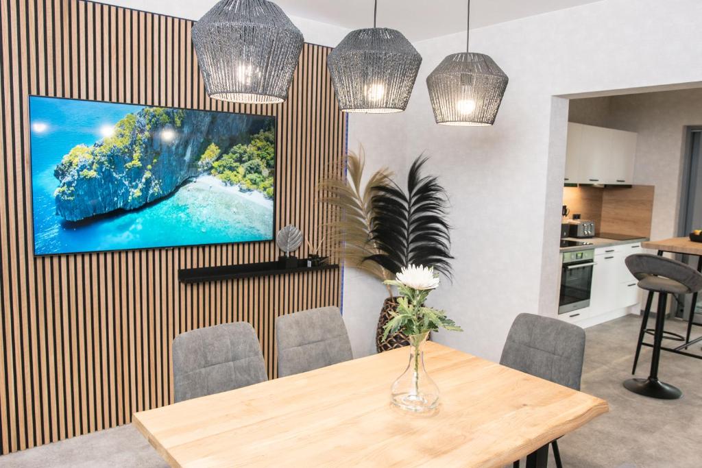 a dining room with a table and a tv on a wall at Triumph Inn Ferienhaus in Rangsdorf