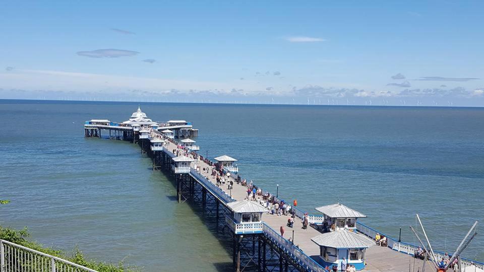 a pier with people on it in the water at BODLONDEB CASTLE BED & BREAKFAST { CENTRAL LLANDUDNO} in Llandudno