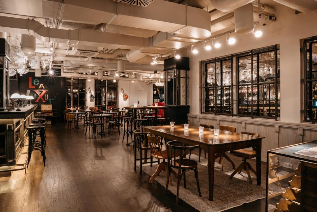 a restaurant with tables and chairs in a room at Ruby Stella Hotel London in London