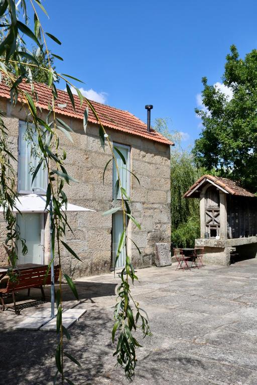 a stone building with a bench and a table at Casa da Eira in Marco de Canaveses