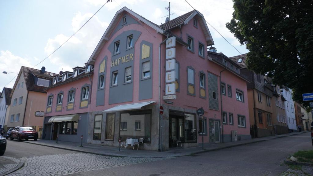 um grande edifício cor-de-rosa numa rua da cidade em Hotel Hafner - Self Check-In em Estugarda