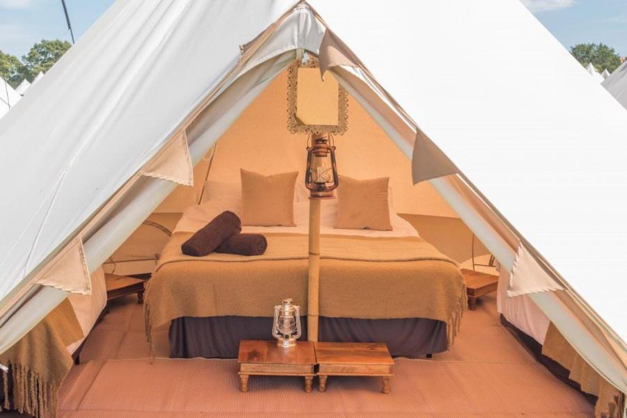 um quarto numa tenda com uma cama e uma mesa em bricktopia em York