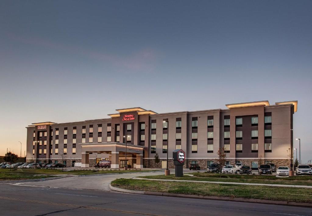 a hotel building with a clock in front of it at Hampton Inn & Suites-Wichita/Airport, KS in Wichita