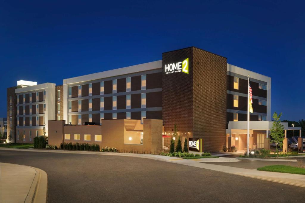 um grande edifício de hotel com um sinal hmc em Home2 Suites By Hilton Menomonee Falls Milwaukee em Menomonee Falls