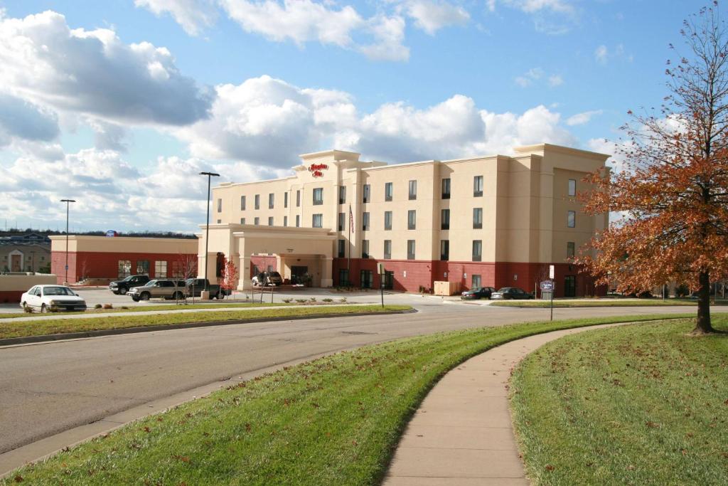 a large white building with a road in front of it at Hampton Inn Topeka in Topeka