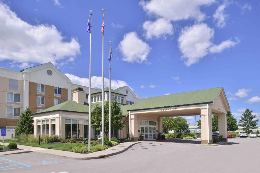 a hotel with two flags in front of a building at Hilton Garden Inn Indianapolis/Carmel in Carmel