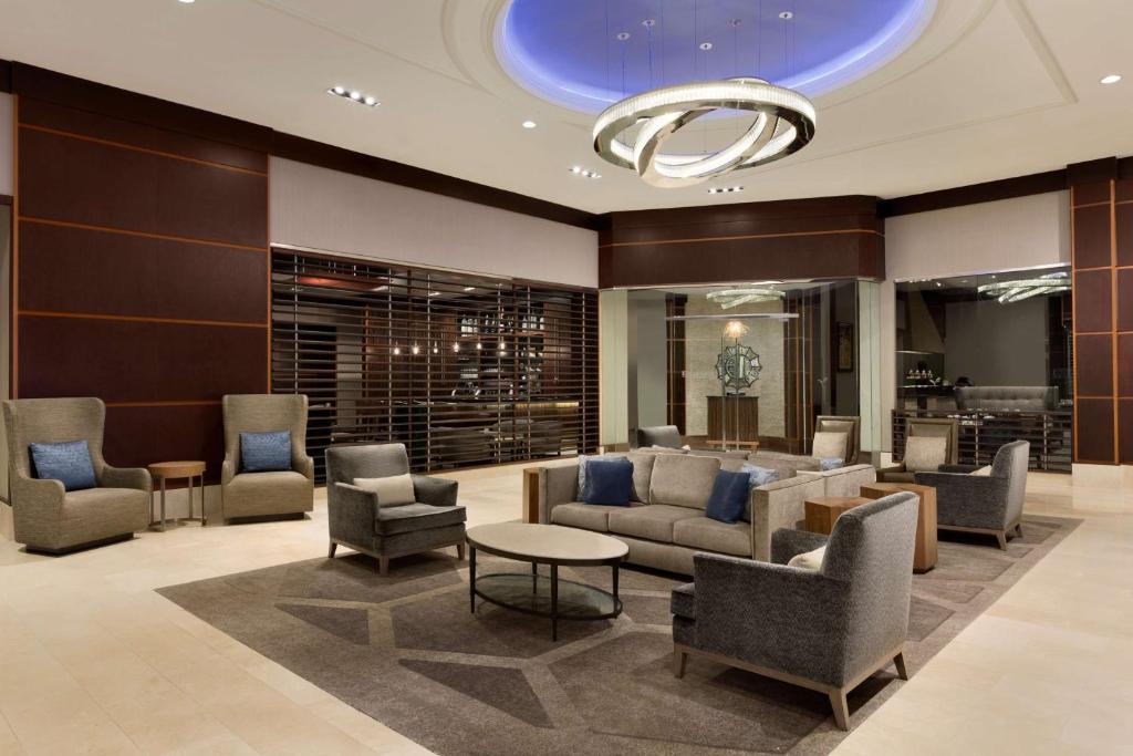 a lobby with couches and chairs and a table at Hilton Philadelphia City Avenue in Philadelphia