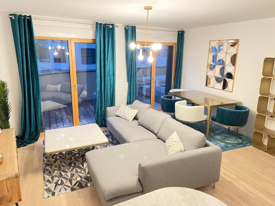uma sala de estar com um sofá e uma mesa em Appartement 4P U Arena em Nanterre