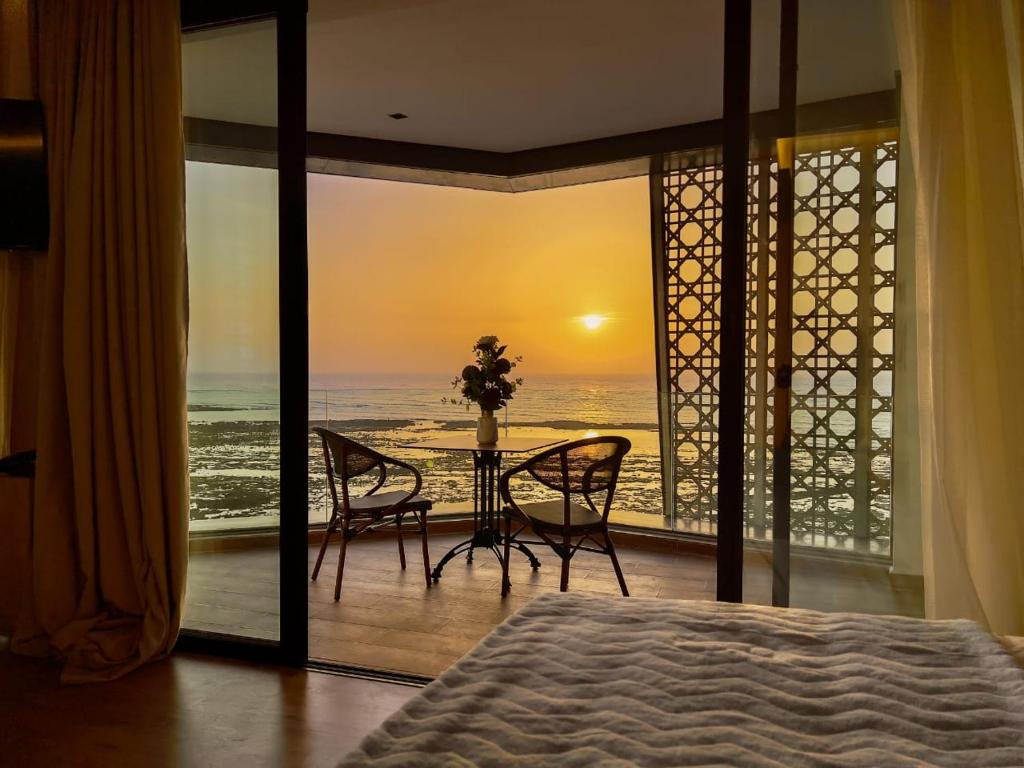 a bedroom with a bed and a view of the ocean at Les Roches De Mazagan in El Jadida