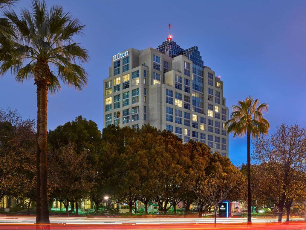 格倫代爾的住宿－北洛杉磯格倫代爾行政會議中心希爾頓酒店，一座高大的建筑,前面有棕榈树