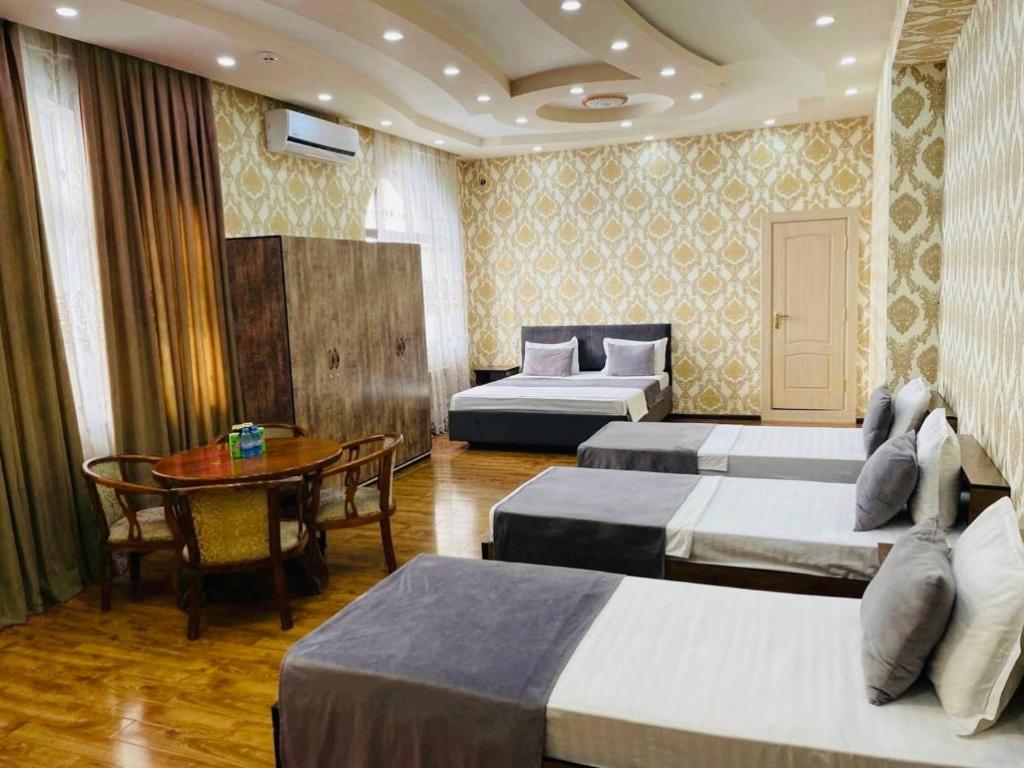 a hotel room with two beds and a table at Voyah Hotel in Tashkent