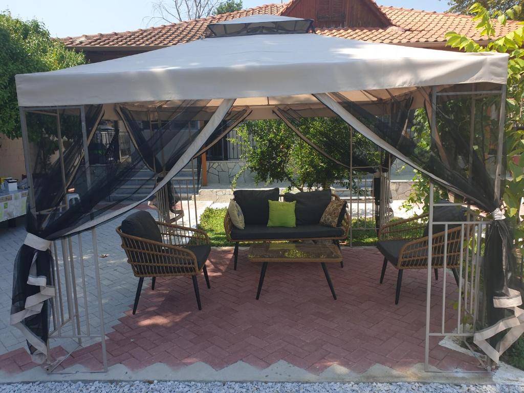 a patio umbrella with chairs and a couch under it at VILLA ARHONTIKO in Asprovalta