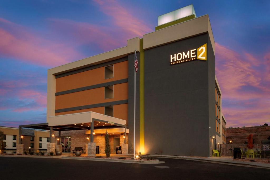ページにあるHome2 Suites By Hilton Page Lake Powellのホームサイン付きのホテルビル