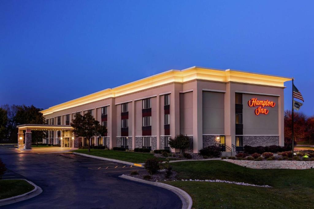 a hotel with a sign on the front of a building at Hampton Inn Milwaukee Airport in Milwaukee