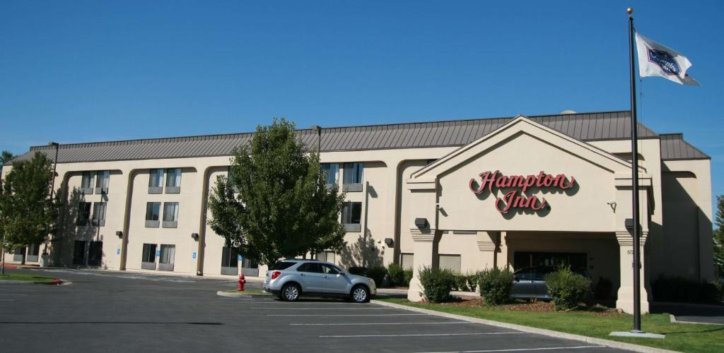 un bâtiment avec une voiture garée sur un parking dans l'établissement Hampton Inn Salt Lake City/Murray, à Murray