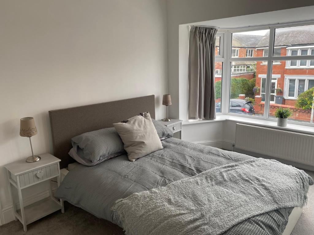 ein Schlafzimmer mit einem Bett mit Kissen und einem Fenster in der Unterkunft Richards Retreat Blackpool in Blackpool