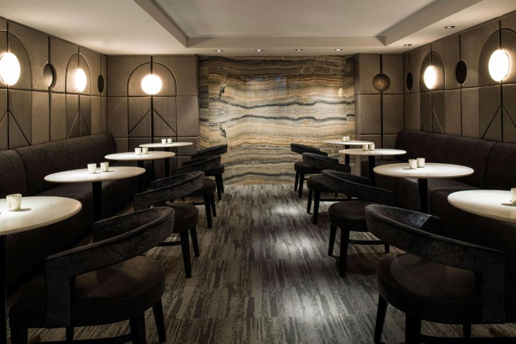 a restaurant with tables and chairs and a stone wall at LondonHouse Chicago, Curio Collection by Hilton in Chicago