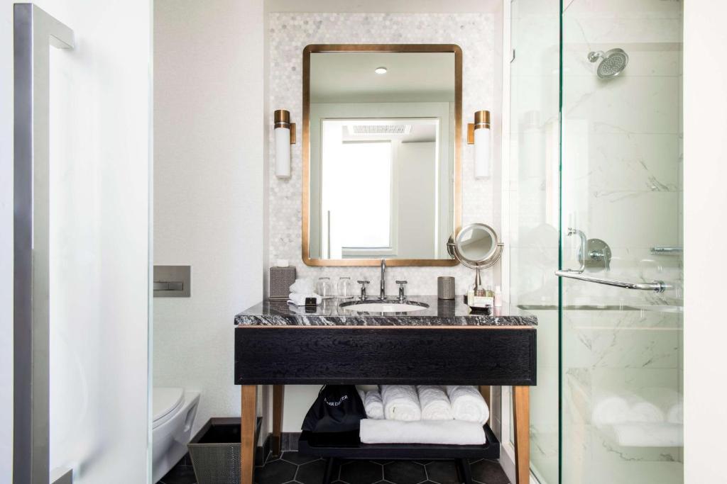 a bathroom with a sink and a mirror at LondonHouse Chicago, Curio Collection by Hilton in Chicago