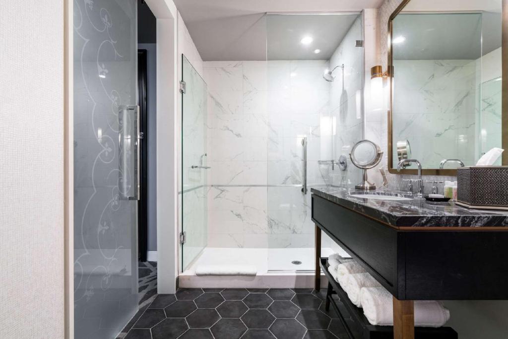 a bathroom with a glass shower and a sink at LondonHouse Chicago, Curio Collection by Hilton in Chicago