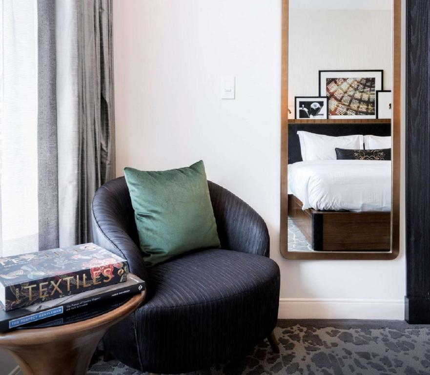 a living room with a chair and a bed at LondonHouse Chicago, Curio Collection by Hilton in Chicago