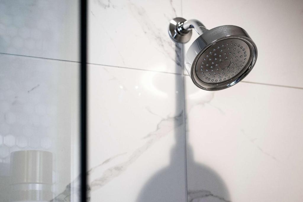 a shower with a shower head on a wall at LondonHouse Chicago, Curio Collection by Hilton in Chicago