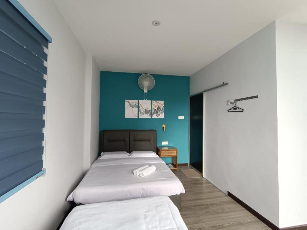 1 dormitorio con 2 camas y pared azul en THE CLOUD KINABALU - R1, R2a en Kundasang