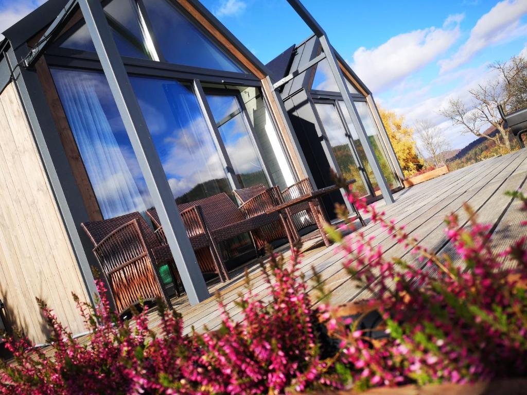 a building with benches and flowers in front of it at Pod Gwiazdami in Cisna