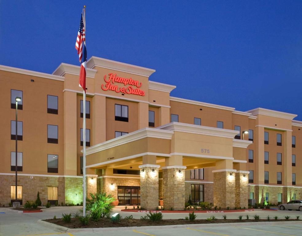 a hotel with an american flag in front of it at Hampton Inn & Suites New Braunfels in New Braunfels