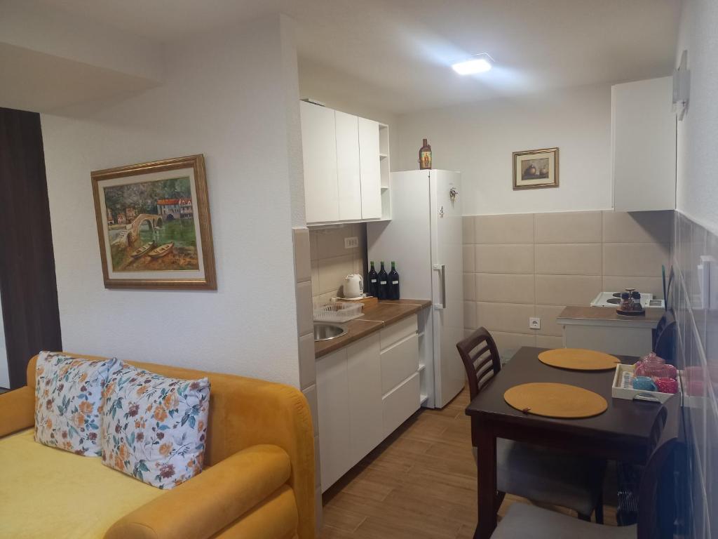 een keuken en een woonkamer met een bank en een tafel bij T-A APARTMENT in Rijeka Crnojevića