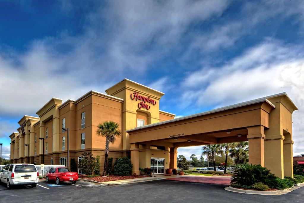 ein Hotel mit einem Auto auf einem Parkplatz in der Unterkunft Hampton Inn Manning in Manning