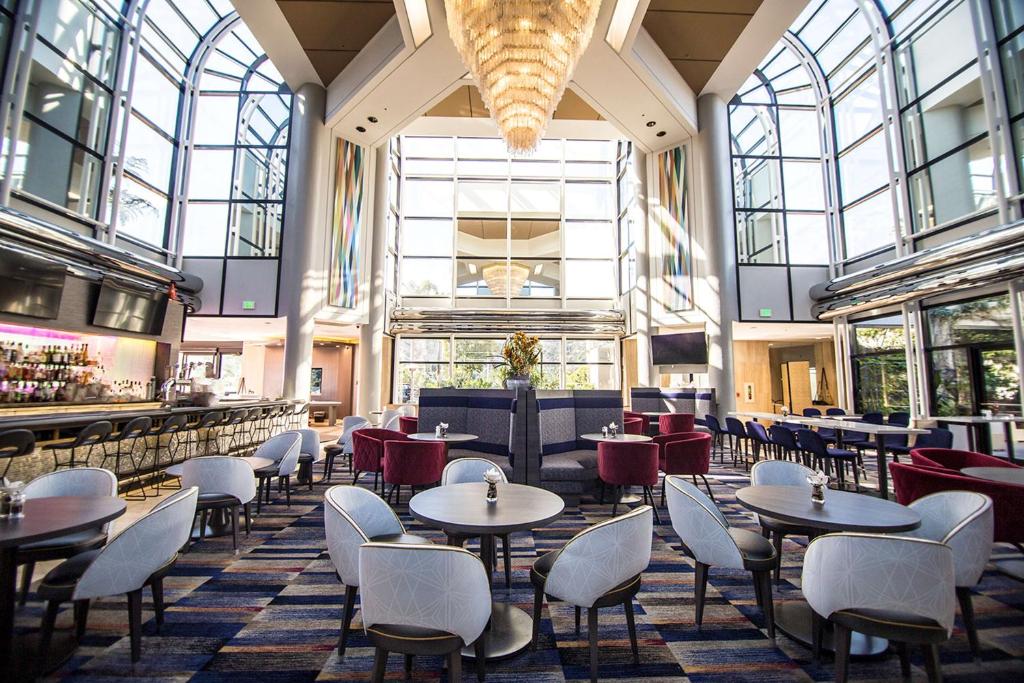 um restaurante com mesas e cadeiras num edifício em Hilton Los Angeles-Universal City em Los Angeles