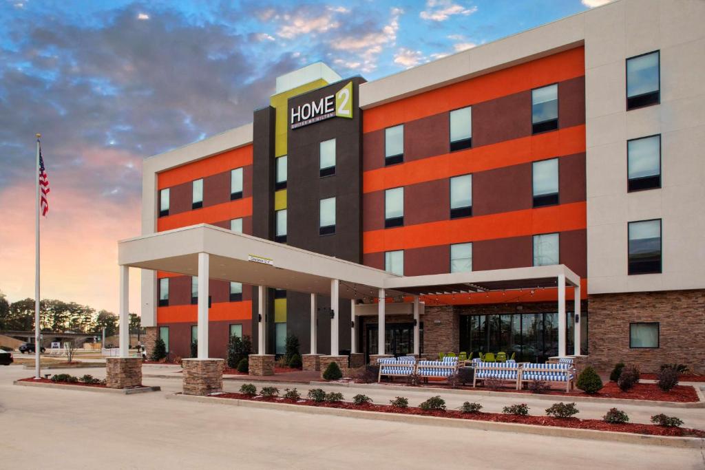 un edificio de oficinas con un cartel en la parte delantera en Home2 Suites By Hilton Lake Charles en Lake Charles