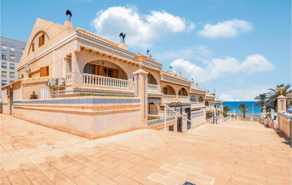 a large building on a sidewalk next to the ocean at Awesome Home In Elche With Wifi in Elche