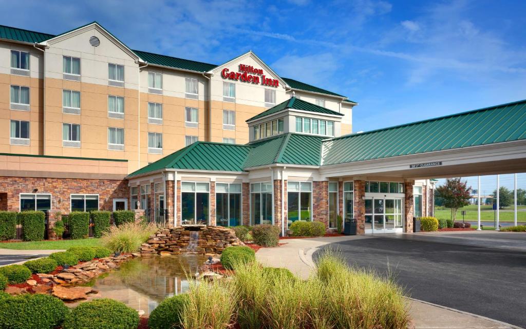 ein Hotelgebäude mit einem Brunnen davor in der Unterkunft Hilton Garden Inn Clarksville in Clarksville